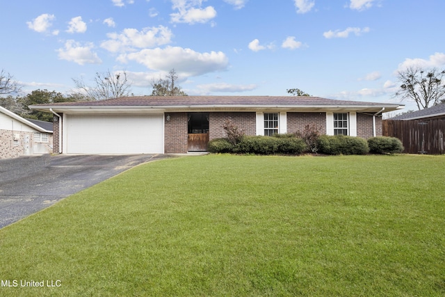 ranch-style home featuring aphalt driveway, an attached garage, brick siding, fence, and a front yard