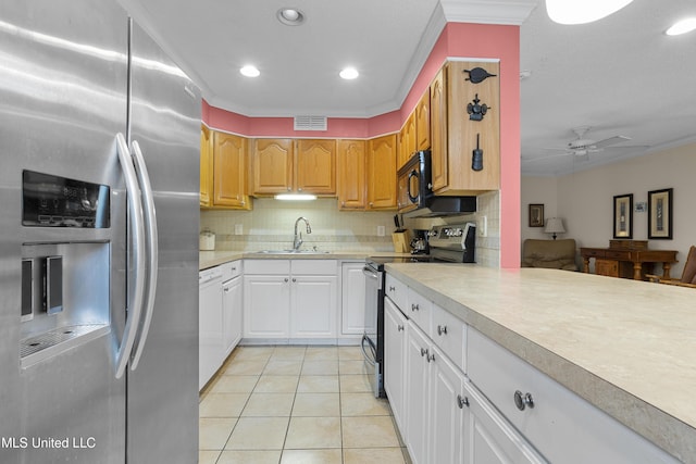 kitchen with light tile patterned floors, decorative backsplash, stainless steel appliances, light countertops, and a sink