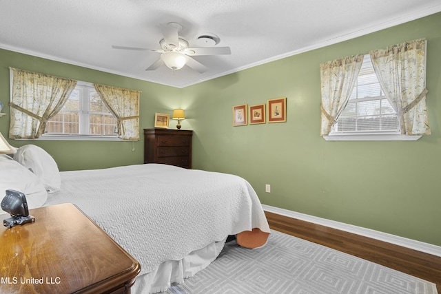 bedroom featuring crown molding, multiple windows, wood finished floors, and baseboards