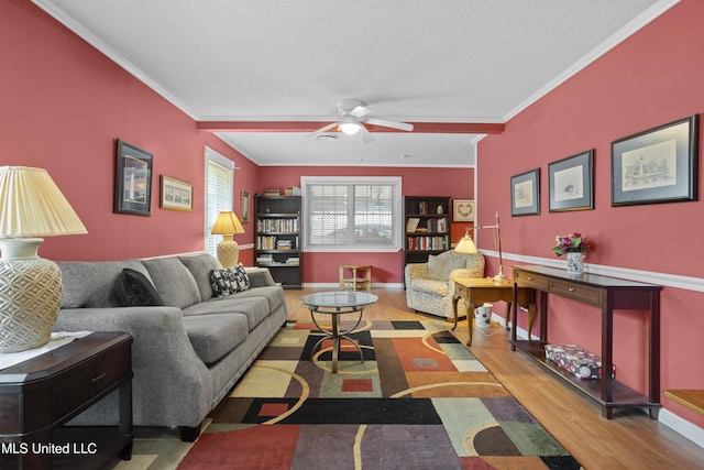 living room with crown molding, baseboards, ceiling fan, and wood finished floors