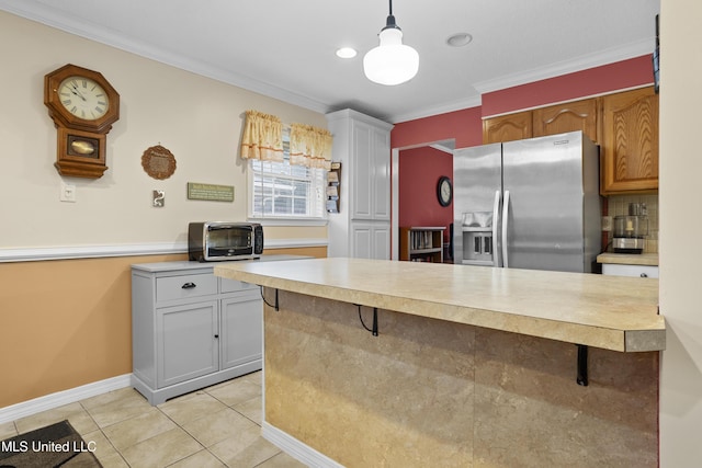 kitchen featuring light tile patterned floors, ornamental molding, a breakfast bar area, and stainless steel refrigerator with ice dispenser