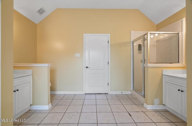 7669 Meadow Ridge Ln, Olive Branch, MS 38654 - full bathroom featuring vaulted ceiling, vanity, a shower stall, tile patterned floors, and baseboards