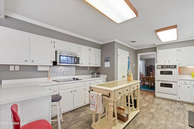 kitchen featuring black electric cooktop, white cabinetry, and double oven