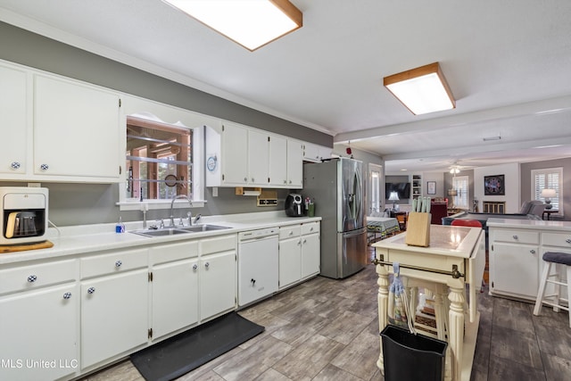 kitchen featuring white cabinetry, a healthy amount of sunlight, white dishwasher, and stainless steel fridge with ice dispenser