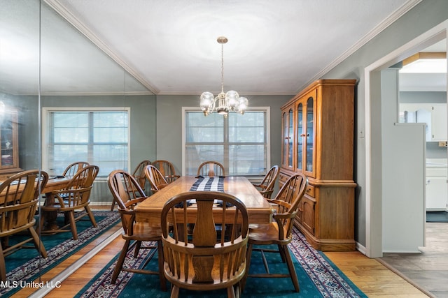 dining room featuring light hardwood / wood-style floors, ornamental molding, and an inviting chandelier