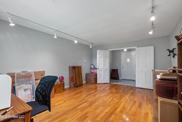 home office with track lighting and light hardwood / wood-style flooring