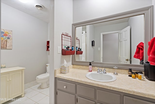 bathroom featuring vanity, toilet, tile patterned floors, and a textured ceiling