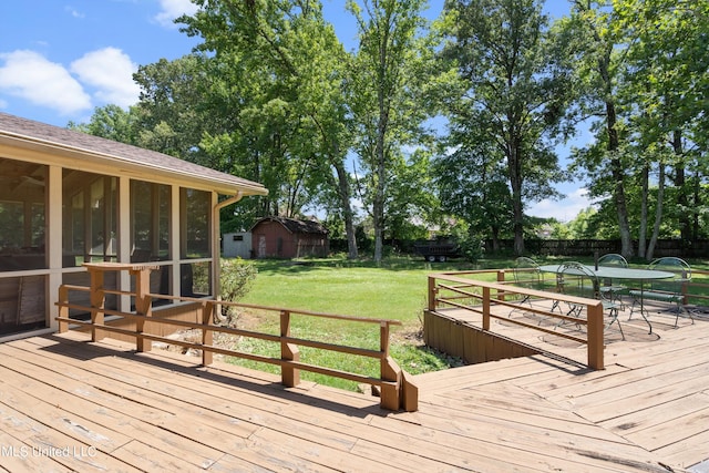 wooden deck featuring a storage shed, a yard, and a sunroom