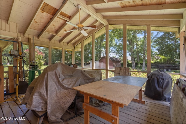 sunroom with ceiling fan, vaulted ceiling with beams, and plenty of natural light