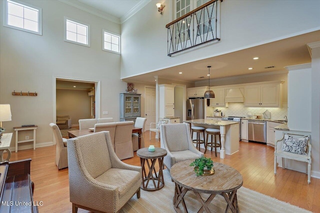 210 Planters Grv, Brandon, MS 39047 - living area with light wood finished floors, crown molding, a high ceiling, recessed lighting, and baseboards