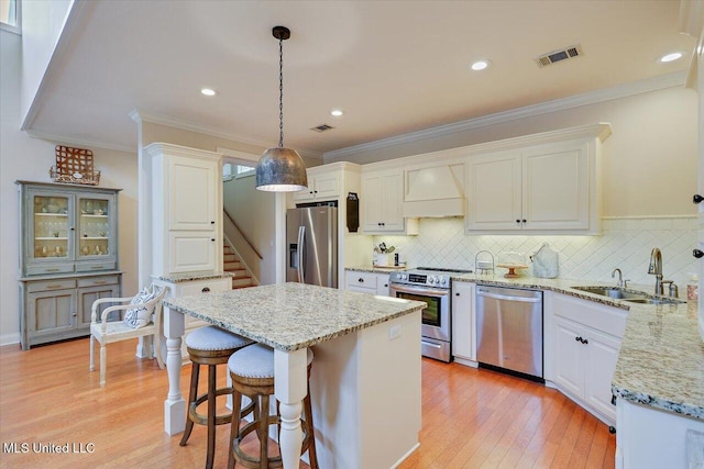 210 Planters Grv, Brandon, MS 39047 - kitchen featuring stainless steel appliances, custom range hood, a sink, light wood-type flooring, and a kitchen island