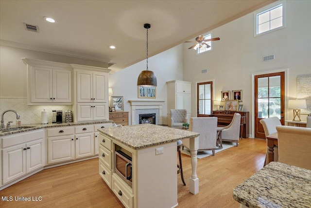 210 Planters Grv, Brandon, MS 39047 - kitchen with stainless steel microwave, a sink, open floor plan, a fireplace, and plenty of natural light