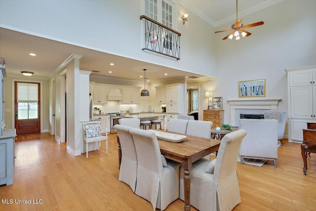 210 Planters Grv, Brandon, MS 39047 - dining area with crown molding, a fireplace, ceiling fan, light wood finished floors, and baseboards