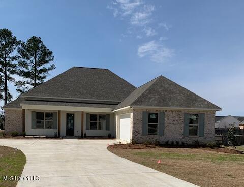 121 Catherine Blvd, Clinton, MS 39056 - view of front facade with driveway, an attached garage, fence, a porch, and brick siding