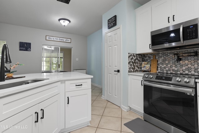 6507 Shoshonee Dr, Ocean Springs, MS 39564 - kitchen featuring stainless steel appliances, a sink, backsplash, light tile patterned flooring, and white cabinets