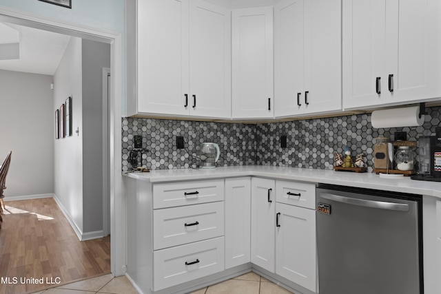 6507 Shoshonee Dr, Ocean Springs, MS 39564 - kitchen featuring stainless steel dishwasher, light countertops, tasteful backsplash, white cabinets, and baseboards