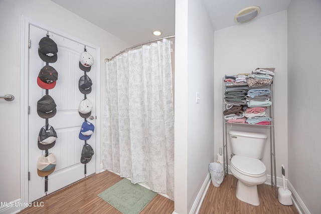 18108 Steamer Way, Gulfport, MS 39503 - bathroom with wood finished floors, toilet, a shower with shower curtain, and baseboards