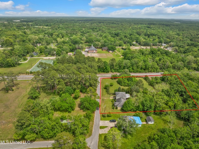 aerial view of property's location with a heavily wooded area and property parcel outlined