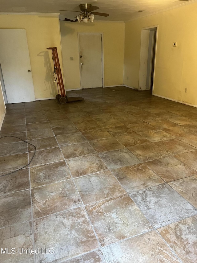 empty room featuring a ceiling fan and stone finish floors