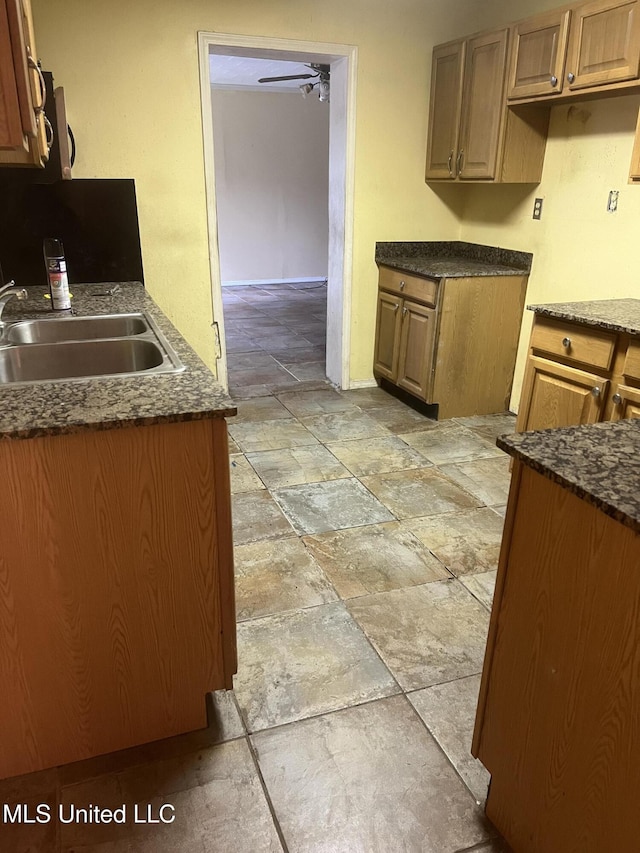 kitchen featuring a sink, stone tile flooring, a ceiling fan, and stainless steel microwave
