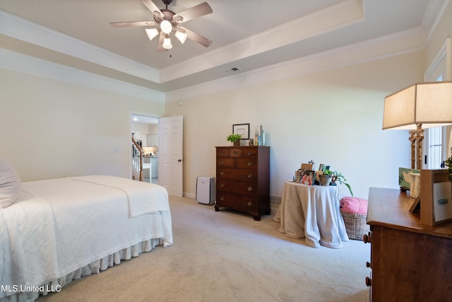 bedroom featuring a raised ceiling, ceiling fan, and light colored carpet