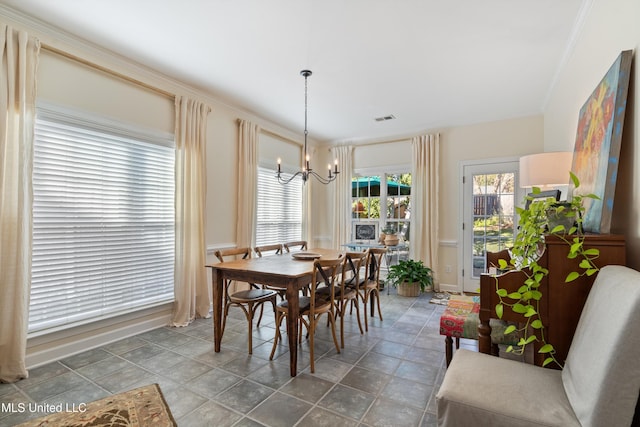 dining room with ornamental molding and a chandelier