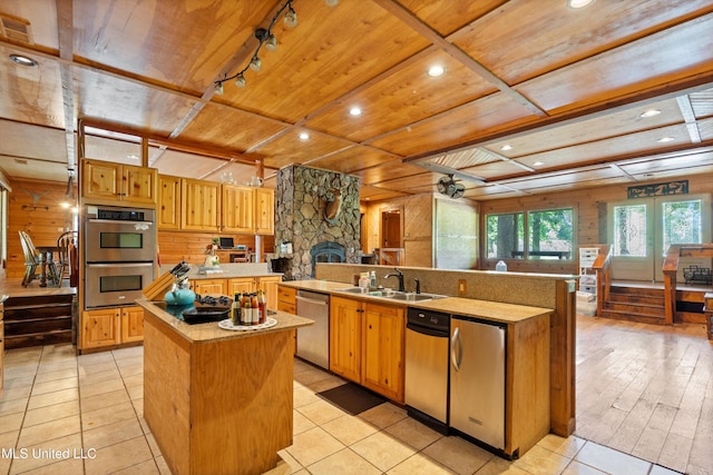 927 Abe Chapel Rd, Como, MS 38619 - kitchen with a center island with sink, wooden ceiling, stainless steel appliances, a sink, and wood walls
