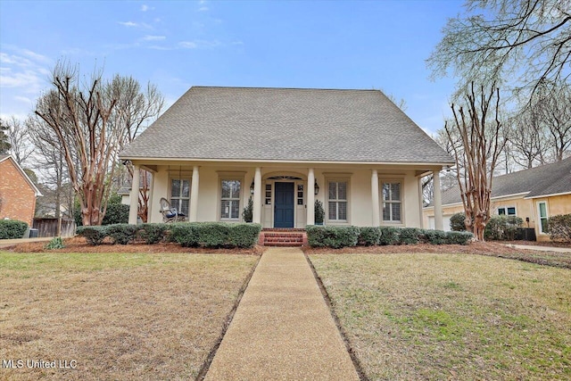 view of front of house with stucco siding, a front yard, and roof with shingles