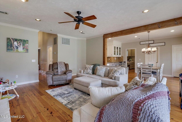 living area with crown molding, light wood-style floors, visible vents, and a textured ceiling