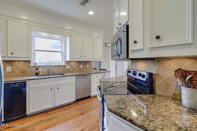 kitchen with visible vents, white cabinets, stainless steel appliances, and a sink