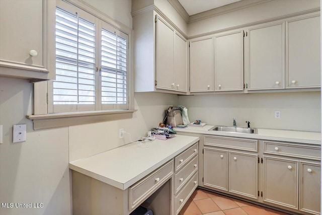 clothes washing area featuring light tile patterned flooring and a sink