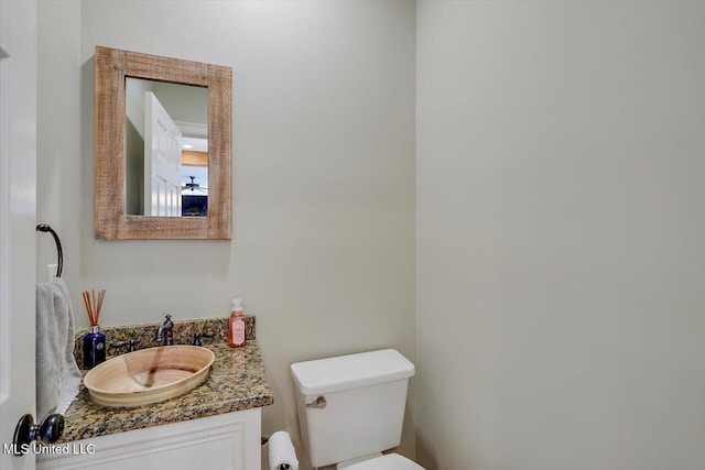 half bathroom with vanity and toilet