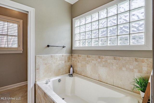 full bathroom featuring tile patterned floors, a bath, and a wealth of natural light