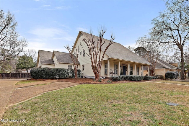 view of front facade featuring covered porch, a front lawn, and fence