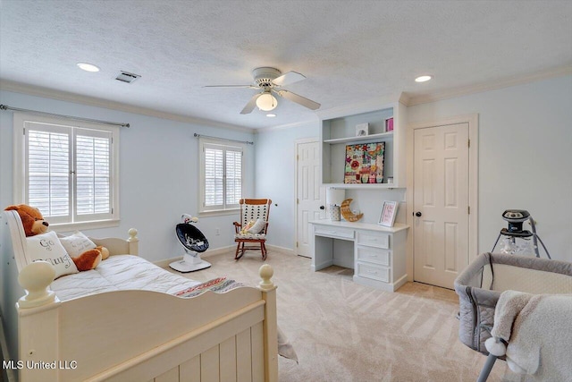 bedroom featuring a ceiling fan, visible vents, ornamental molding, a textured ceiling, and light colored carpet