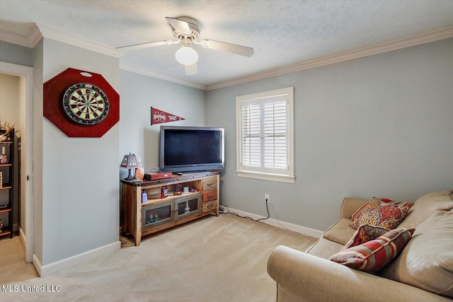 living area featuring a textured ceiling, ornamental molding, ceiling fan, and light carpet