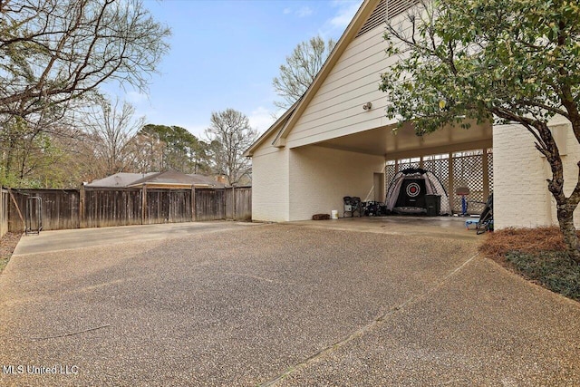 view of vehicle parking featuring driveway and fence