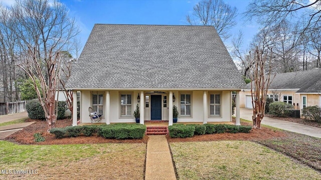 view of front of property featuring stucco siding, a porch, a front lawn, and fence