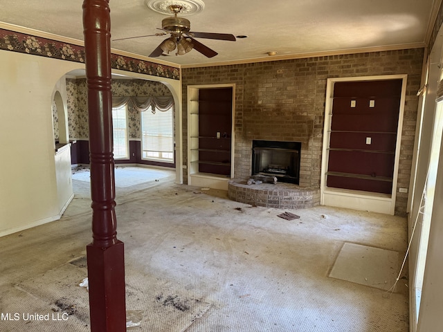 407 N Thunderbird Rd, Hernando, MS 38632 - unfurnished living room with carpet, crown molding, arched walkways, ceiling fan, and a fireplace
