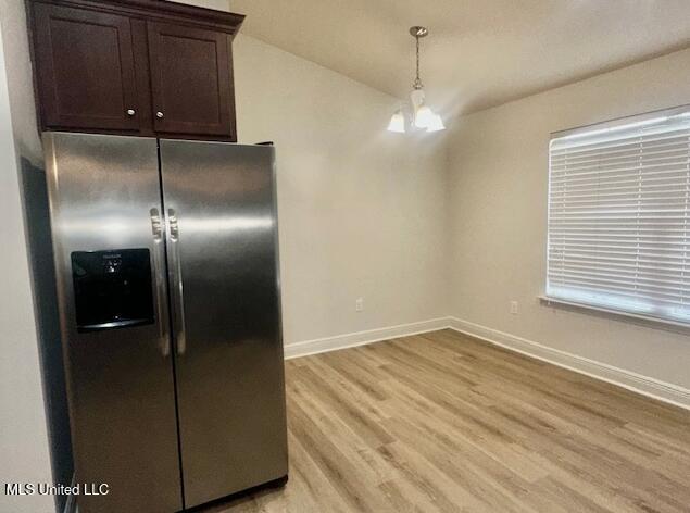 14816 Canal Crossing Blvd, Gulfport, MS 39503 - kitchen featuring stainless steel fridge, dark brown cabinets, light wood finished floors, and decorative light fixtures