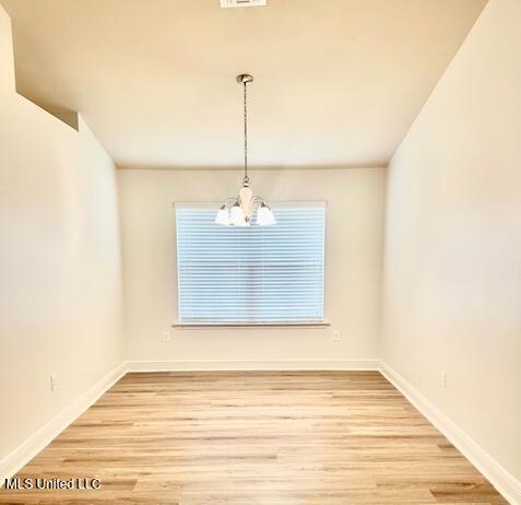 14816 Canal Crossing Blvd, Gulfport, MS 39503 - unfurnished dining area with a chandelier and wood finished floors