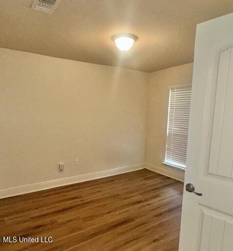 14816 Canal Crossing Blvd, Gulfport, MS 39503 - spare room featuring dark wood-style flooring and baseboards