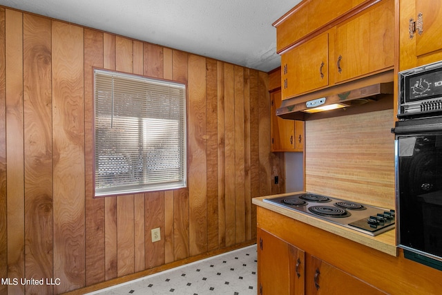 kitchen with wood walls, oven, and stainless steel electric cooktop