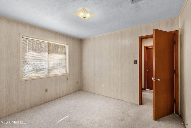 219 E Jackson St, Ridgeland, MS 39157 - spare room with a textured ceiling, wooden walls, and carpet