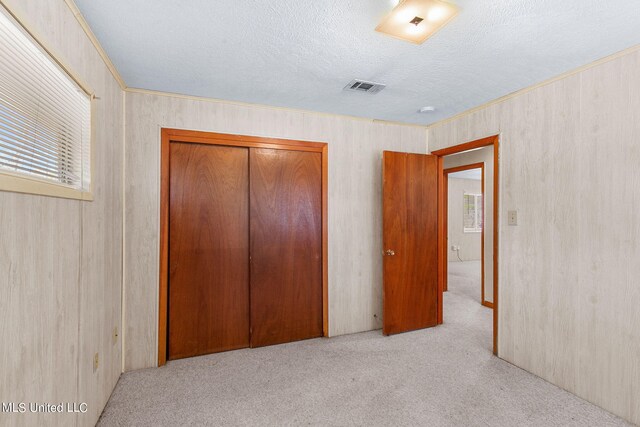 219 E Jackson St, Ridgeland, MS 39157 - unfurnished bedroom featuring crown molding, a textured ceiling, a closet, carpet floors, and visible vents