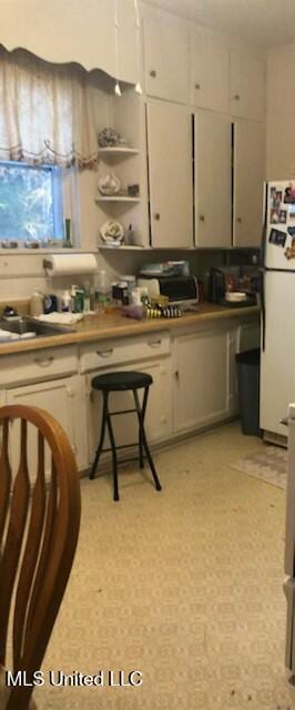 109 Hightower St, Sardis, MS 38666 - kitchen featuring freestanding refrigerator, white cabinetry, and open shelves