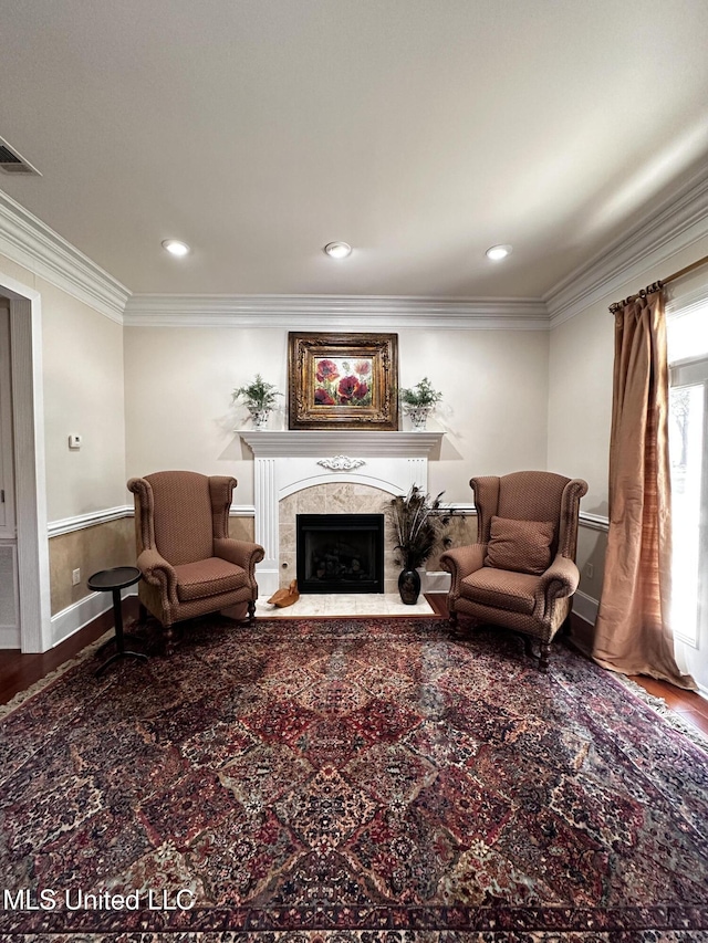 living room with crown molding and a high end fireplace