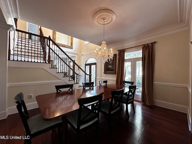 dining area featuring ornamental molding, dark hardwood / wood-style floors, a notable chandelier, and french doors