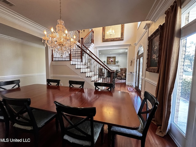 dining room with dark hardwood / wood-style flooring, crown molding, and an inviting chandelier