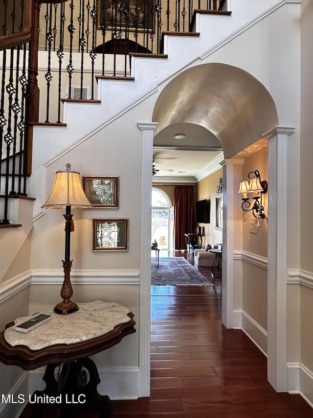 corridor with ornate columns, ornamental molding, and dark hardwood / wood-style floors